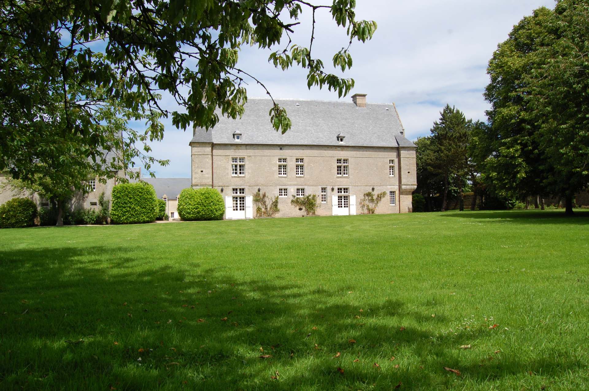 Utsikt över den stora Crépon -gården, med historisk fasad och Green Park i Normandie.