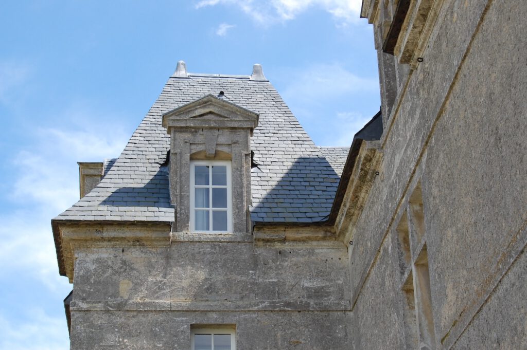 Arkitektonisk detalj av en historisk stuga vid Grande Ferme de Crépon, Normandie, med ett skiffertak.