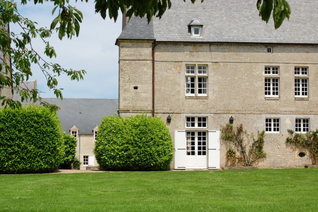 Gîte le Colimçon på Grande Ferme de Crépon, Normandie, med trädgård och historisk arkitektur.